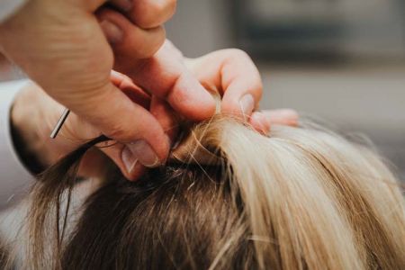 Haare werden an Haarteil befestigt