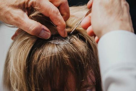Haare werden durch Vorrichtung gezogen