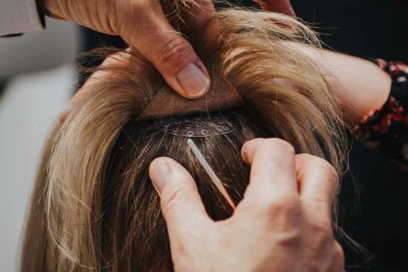 Haarersatz wird an Kopf befestigt